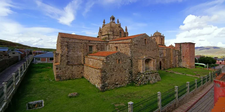 Igreja de Santiago Apóstol em Lampa, Peru. Uma construção colonial de pedra com cúpula central e torres, construída sobre fundações incas. Um monumento histórico no departamento de Puno, ideal para explorar a arquitetura barroca e a fusão das culturas andina e colonial. Um destino turístico cultural no sul do Peru.