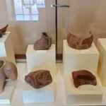 Exposição de artefatos arqueológicos no Museu Pucará, Peru. Cerâmicas pré-incas da cultura Colla, incluindo vasos, jarros e figuras de animais. Fragmentos de potes e xícaras decorados com motivos geométricos. Um destino cultural em Puno, ideal para aprender sobre a história antiga e a arte andina do sul do Peru.