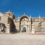 Igreja de Santiago Apóstol em Pucará de Lampa, Peru. Uma construção colonial de pedra com fachada barroca, cúpula central e detalhes ornamentais. Um monumento histórico no departamento de Puno, ideal para explorar a arquitetura religiosa e a história cultural do sul do Peru. Vista frontal da praça principal.