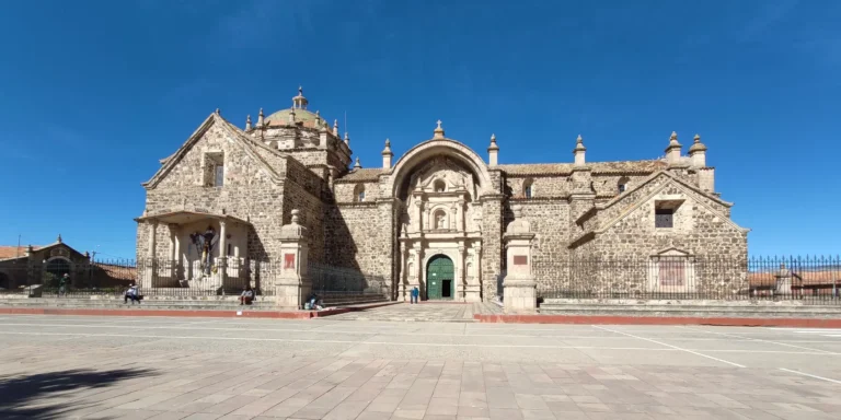 Igreja de Santiago Apóstol em Pucará de Lampa, Peru. Uma construção colonial de pedra com fachada barroca, cúpula central e detalhes ornamentais. Um monumento histórico no departamento de Puno, ideal para explorar a arquitetura religiosa e a história cultural do sul do Peru. Vista frontal da praça principal.
