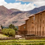 Raqchi Ruins in Cusco, Peru, with adobe and Inca stone buildings surrounded by Andean mountains. A sacred Inca archaeological site dedicated to the worship of the god Viracocha, it is a key stop for pilgrims and tourists.