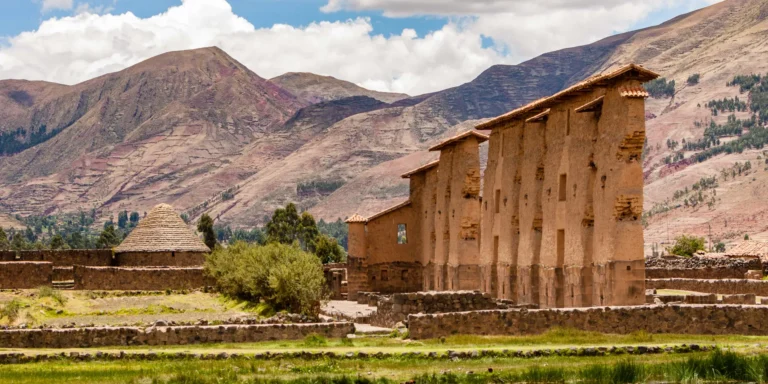 Raqchi Ruins in Cusco, Peru, with adobe and Inca stone buildings surrounded by Andean mountains. A sacred Inca archaeological site dedicated to the worship of the god Viracocha, it is a key stop for pilgrims and tourists.