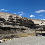 Ponto de partida para o passeio às Cataratas de Pillones, Peru – uma paisagem desértica com formações rochosas e uma barraca de artesanato no planalto andino, um destino turístico no sul do país.
