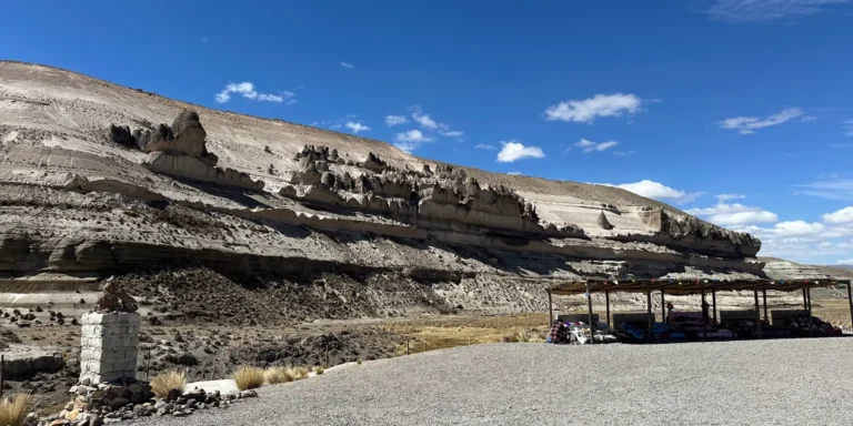 Ponto de partida para o passeio às Cataratas de Pillones, Peru – uma paisagem desértica com formações rochosas e uma barraca de artesanato no planalto andino, um destino turístico no sul do país.