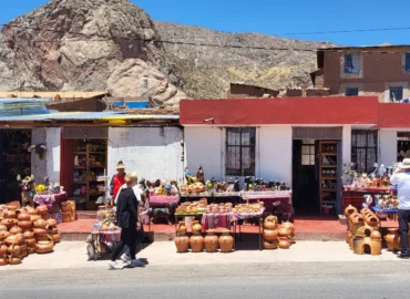 Mercado de artesanato em Pucará de Lampa, Peru. Lojas ao ar livre vendem cerâmica tradicional, incluindo potes, vasos e figuras esculpidas. Artesãos locais expõem seus produtos em uma praça com construções de adobe e as montanhas do Altiplano ao fundo. Um destino cultural em Puno, ideal para comprar artesanato autêntico e aprender sobre a história andina.