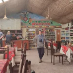 Interior do restaurante Inkawasi em Pampa de los Arrieros, Arequipa – um café temático com decoração andina, mesas com toalhas tradicionais e turistas apreciando comida típica peruana.