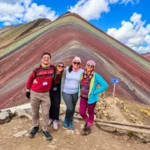 Grupo de turistas posando frente a la Montaña de Colores Vinicunca durante su visita en Cusco, Perú