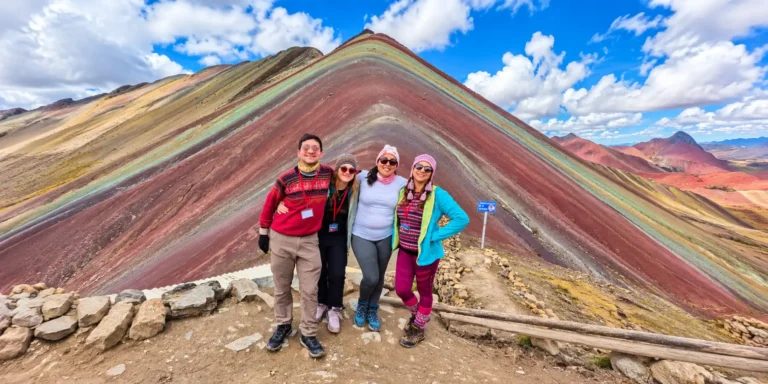 Grupo de turistas posando frente a la Montaña de Colores Vinicunca durante su visita en Cusco, Perú