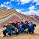 Grupo de turistas posando frente a la Montaña de Colores Vinicunca durante su excursión en Cusco, Perú