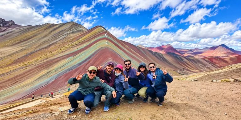Grupo de turistas posando frente a la Montaña de Colores Vinicunca durante su excursión en Cusco, Perú