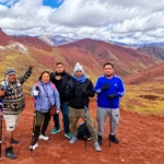 Grupo de turistas con bastones de trekking durante la caminata por el Valle Rojo cerca de la Montaña de Colores, Cusco, Perú