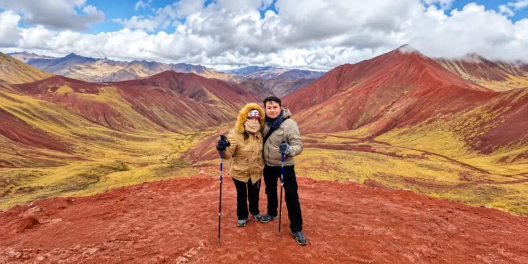 Pareja de turistas con bastones de trekking disfrutando del paisaje del Valle Rojo cerca de la Montaña de Colores, Cusco, Perú